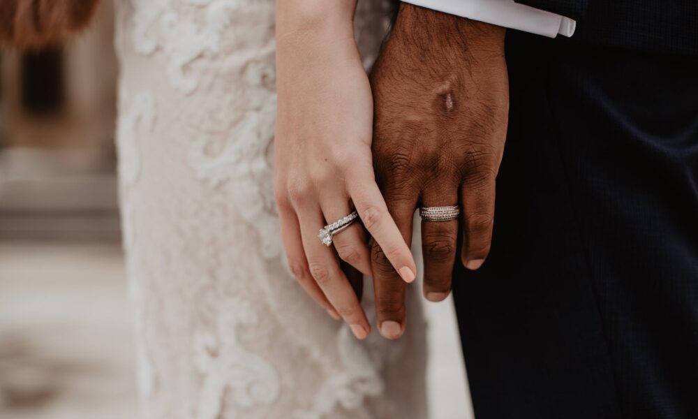 two persons wearing silver colored rings