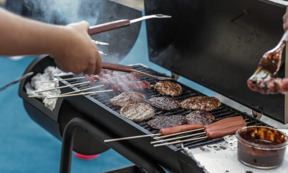 person grilling sausage and meat