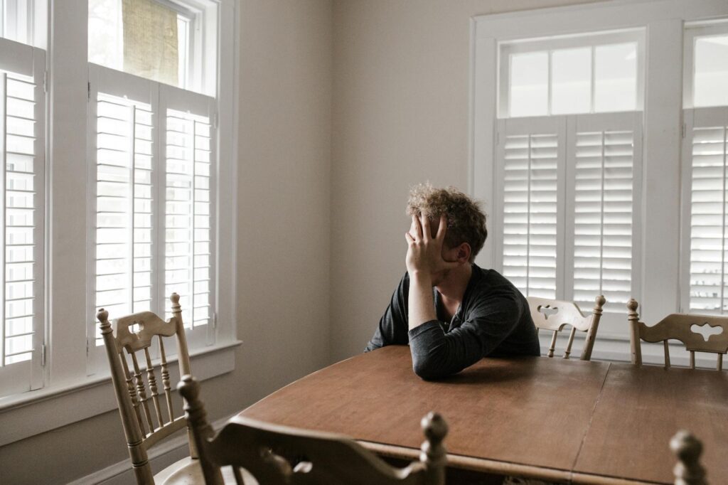 photo of man leaning on wooden table. bacteria