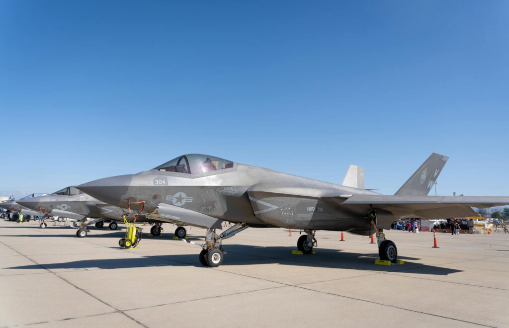 A parked F-35 stealth fighter sits on an airfield. Its sleek and modern design showcases its advanced technology. The fighter's stealth characteristics can be seen through its streamlined shape and radar-absorbing materials. The aircraft exudes power and readiness, ready to take flight at a moment's notice.