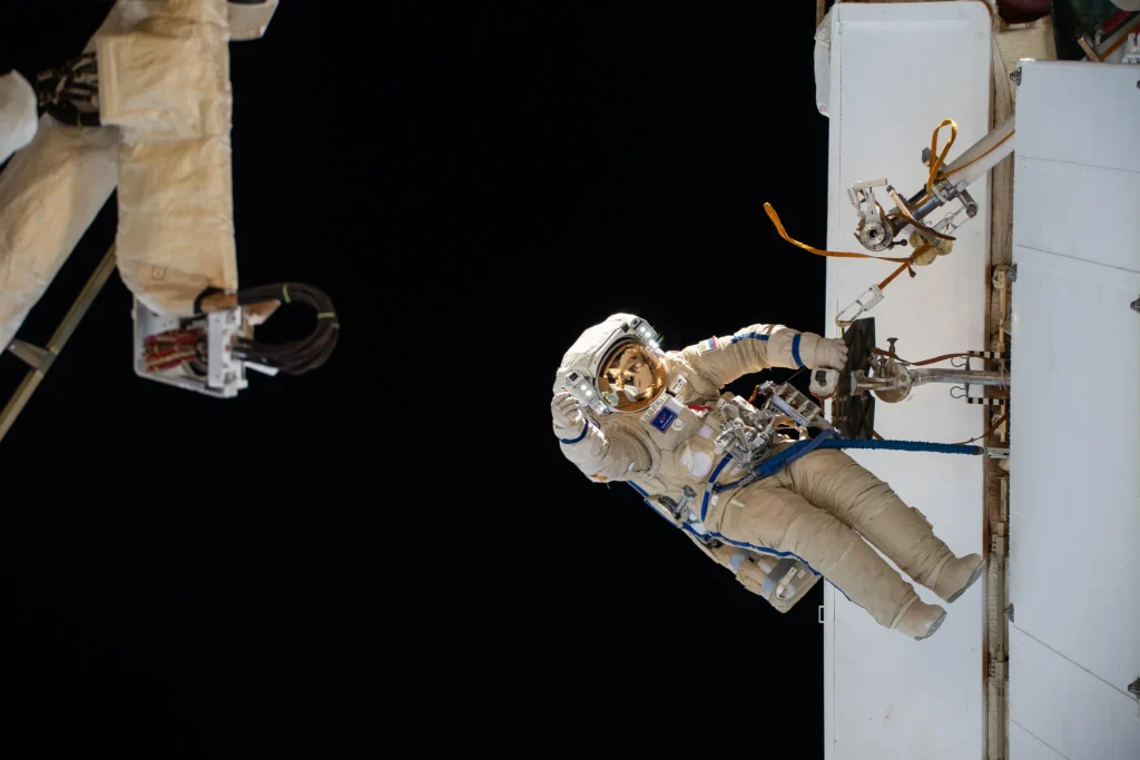 "Two cosmonauts conducting a spacewalk outside the International Space Station"