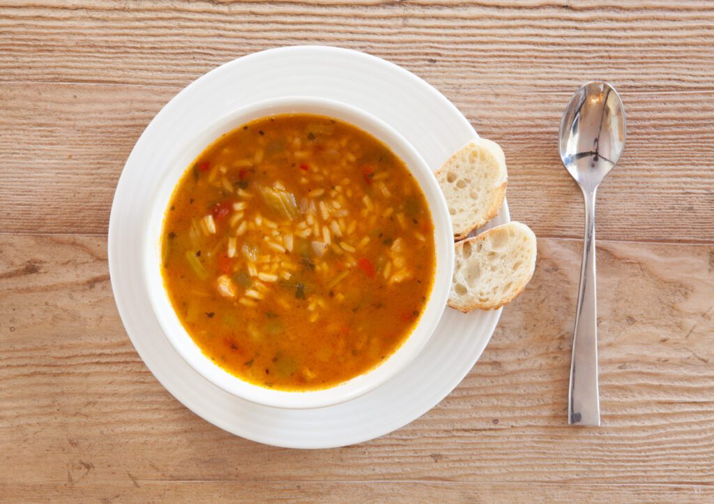 "Image: A steaming bowl of homemade chicken gumbo, filled with tender chicken, vegetables, and aromatic spices."