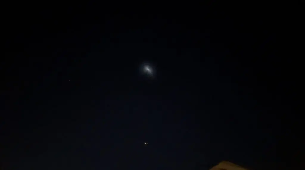 Alt text: Image of a night sky with a glowing unidentified object and clouds, representing the mysterious UFO sightings in Arizona and California.