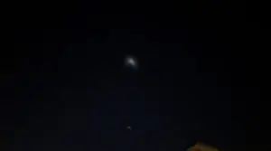 Alt text: Image of a night sky with a glowing unidentified object and clouds, representing the mysterious UFO sightings in Arizona and California.