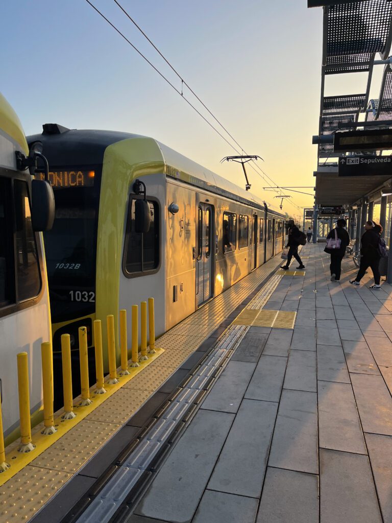 An image showing a Metro train in Los Angeles with transit police officers patrolling the station, ensuring safety and security for passengers. Policing Surge