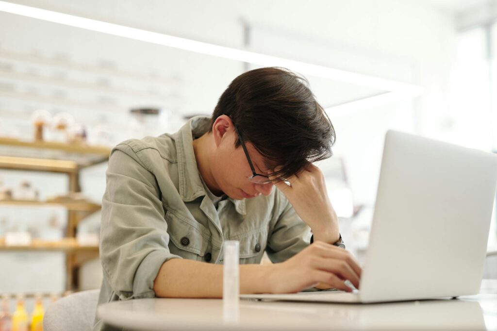 a man looking sick while working with his laptop. security flaw