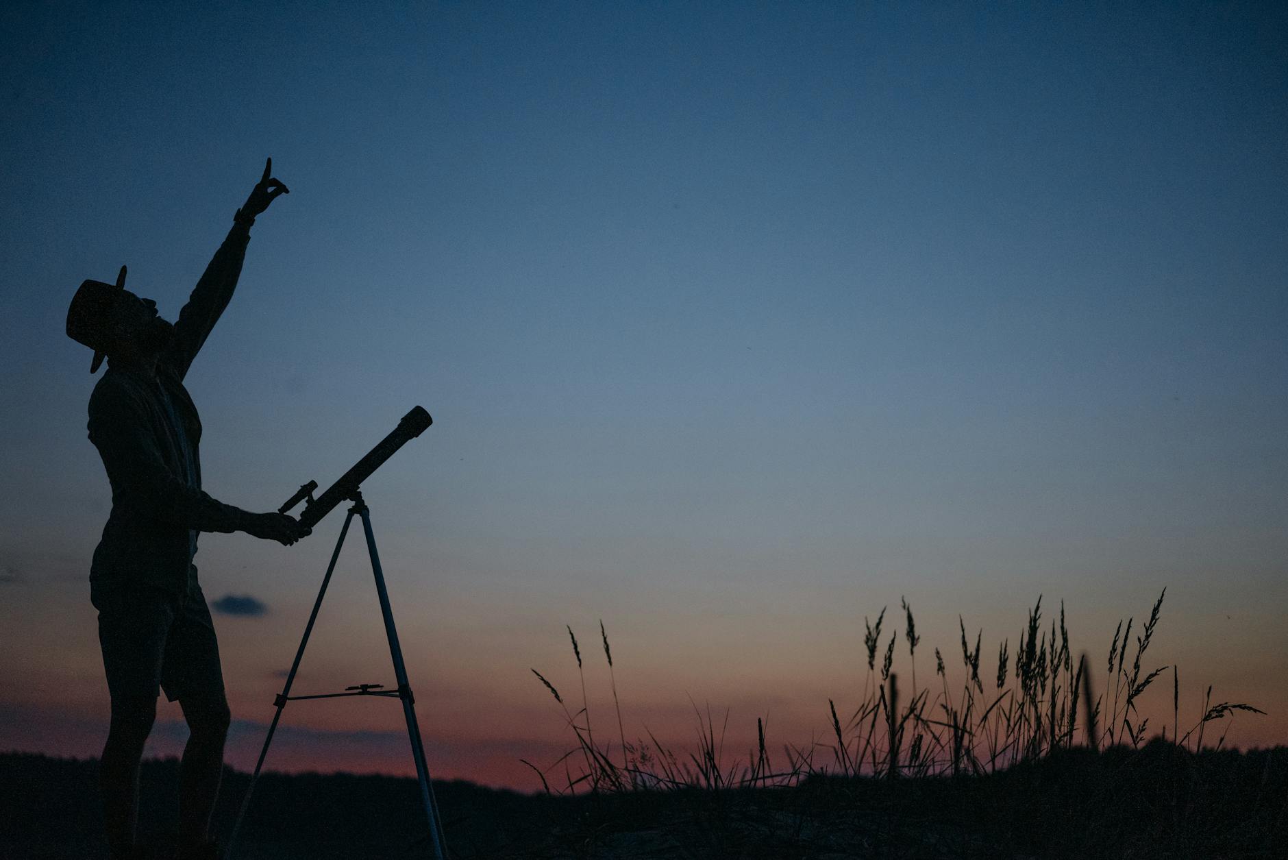 man with telescope watching sky