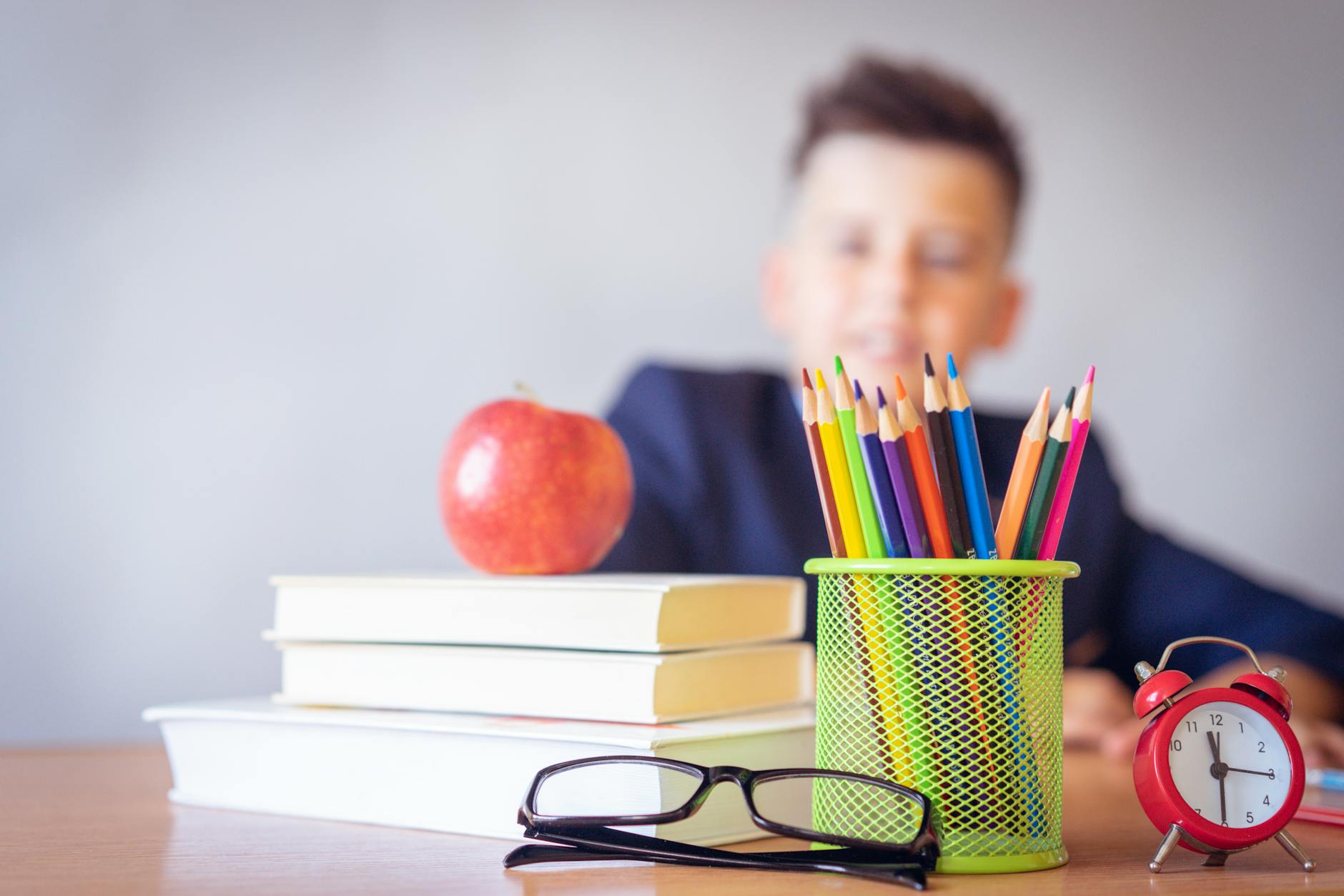 boy looking on a tidied desk at school. 