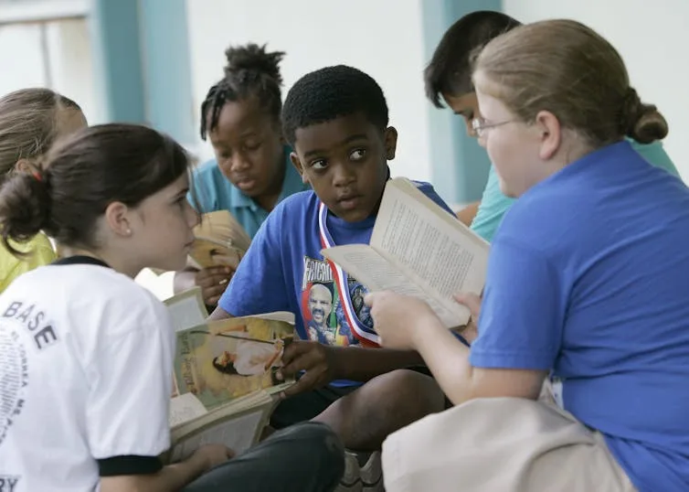 Teacher reading a book to a group of children