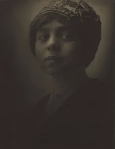 Sepia portrait of young woman with tight-fitting knit hat.