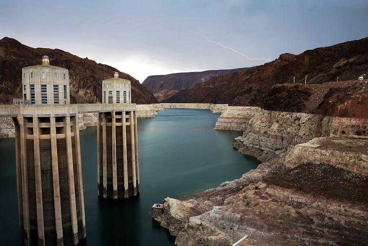 A lake with rings showing the water level drop. Towers for water intake are visible.