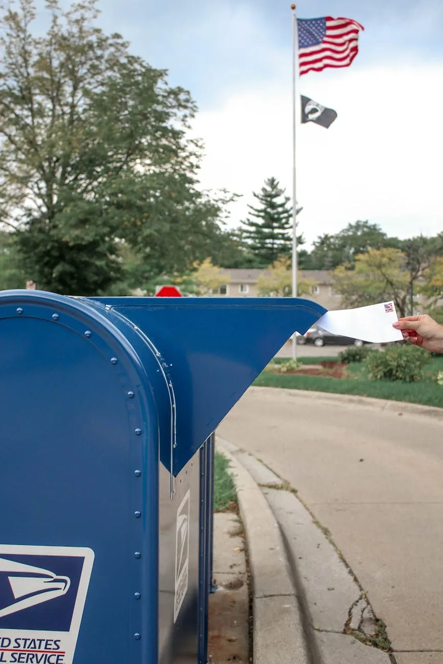 crop person putting envelope in mailbox on street. United States Postal Service 