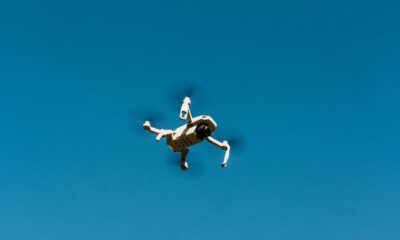low angle shot of a white drone camera flying in the blue sky
