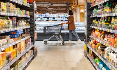 a woman with a cart walks between rows of shelves 2026 01 08 07 26 35 utc